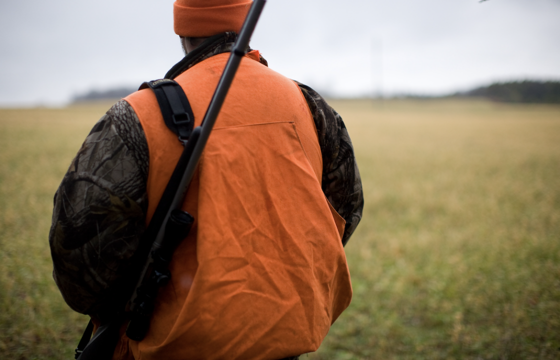 image of hunter in orange vest in field