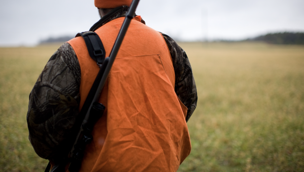image of hunter in orange vest in field